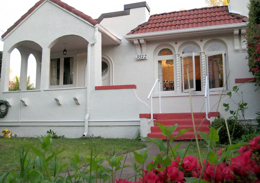 Fresh white exterior painting on a Spanish-style Vancouver home with red tile accents for a clean, inviting finish.