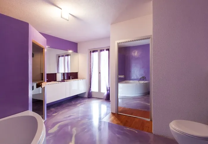 The unique and luxurious purple bathroom walls creates an inviting and relaxing atmosphere.