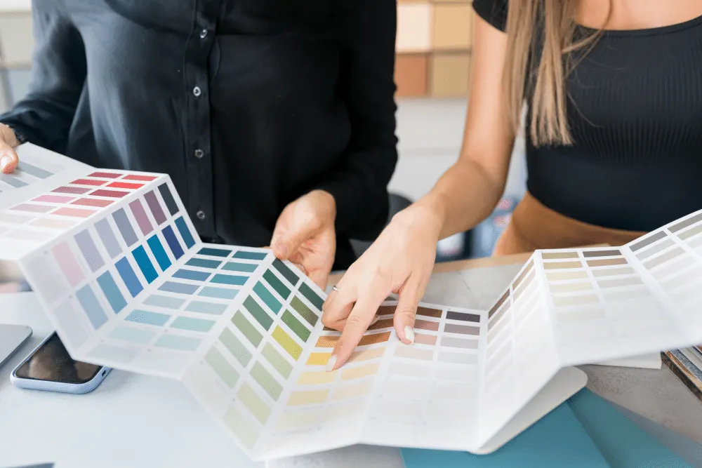 Professionals discussing paint colors with swatches for home renovation, focus on color options.