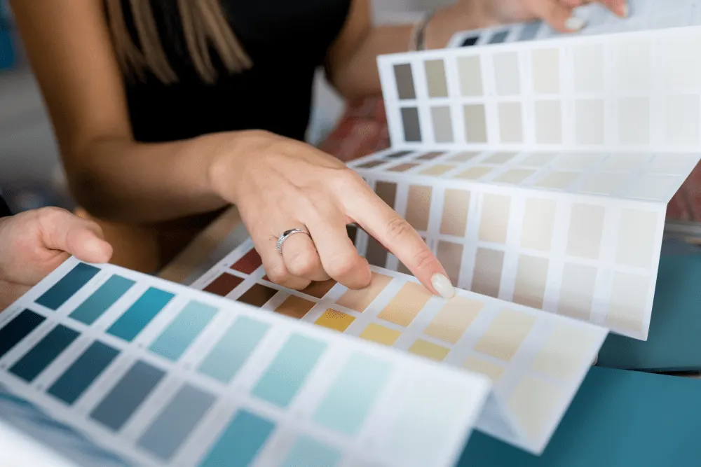 Professionals discussing paint colors with swatches for home renovation, focus on color options.