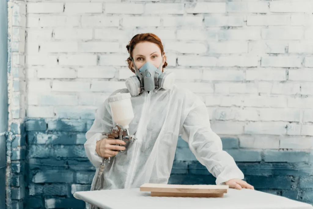 A woman painter with a spray painting machine.