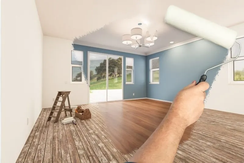 A hand is renovating a room with a roller.