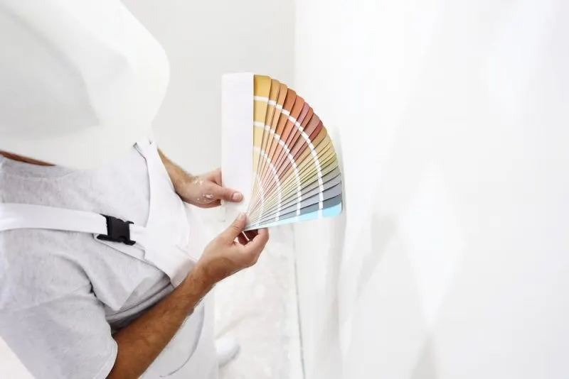 A painter is looking at colour chips.