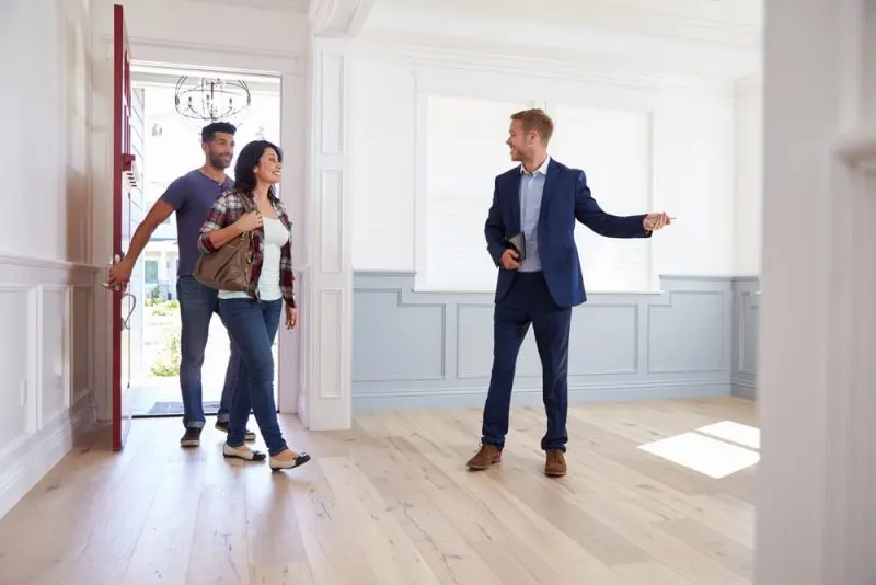 A contractor is showing a renovated house to a couple.