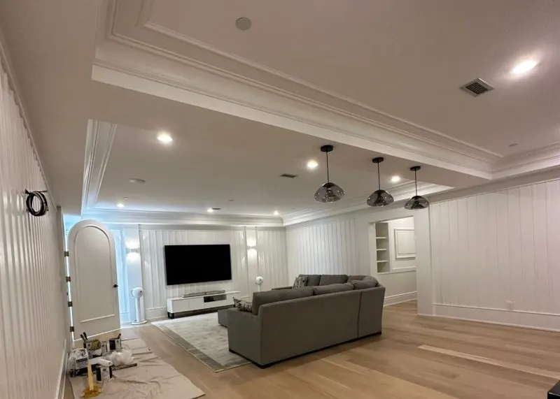 Classic White Room with a grey couch in front of TV