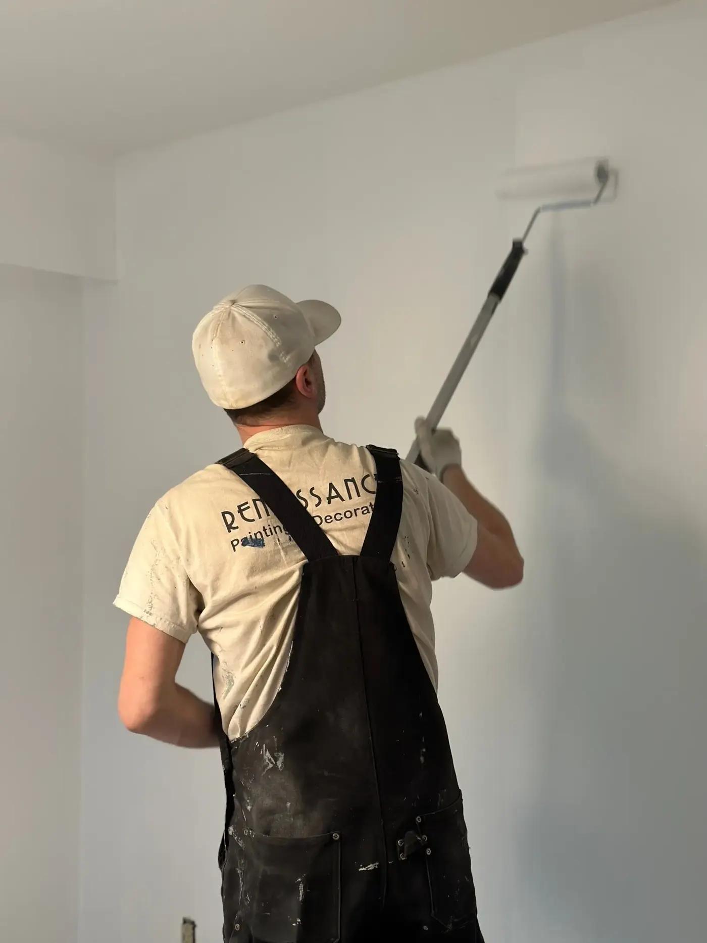 A professional painter painting a wall in a house