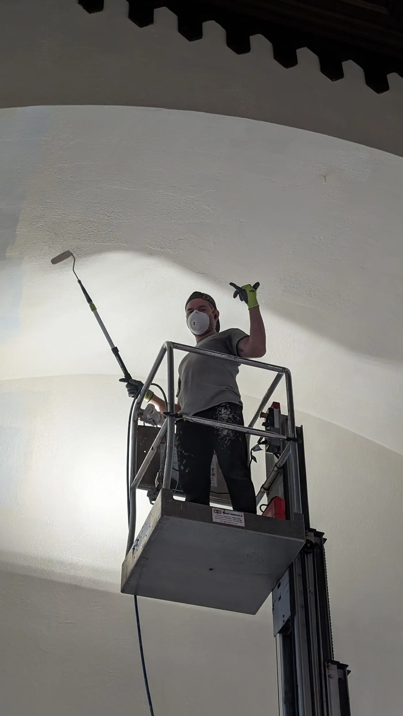 Professional popcorn ceiling texture removal and refinishing using roller technique for a smooth modern finish.