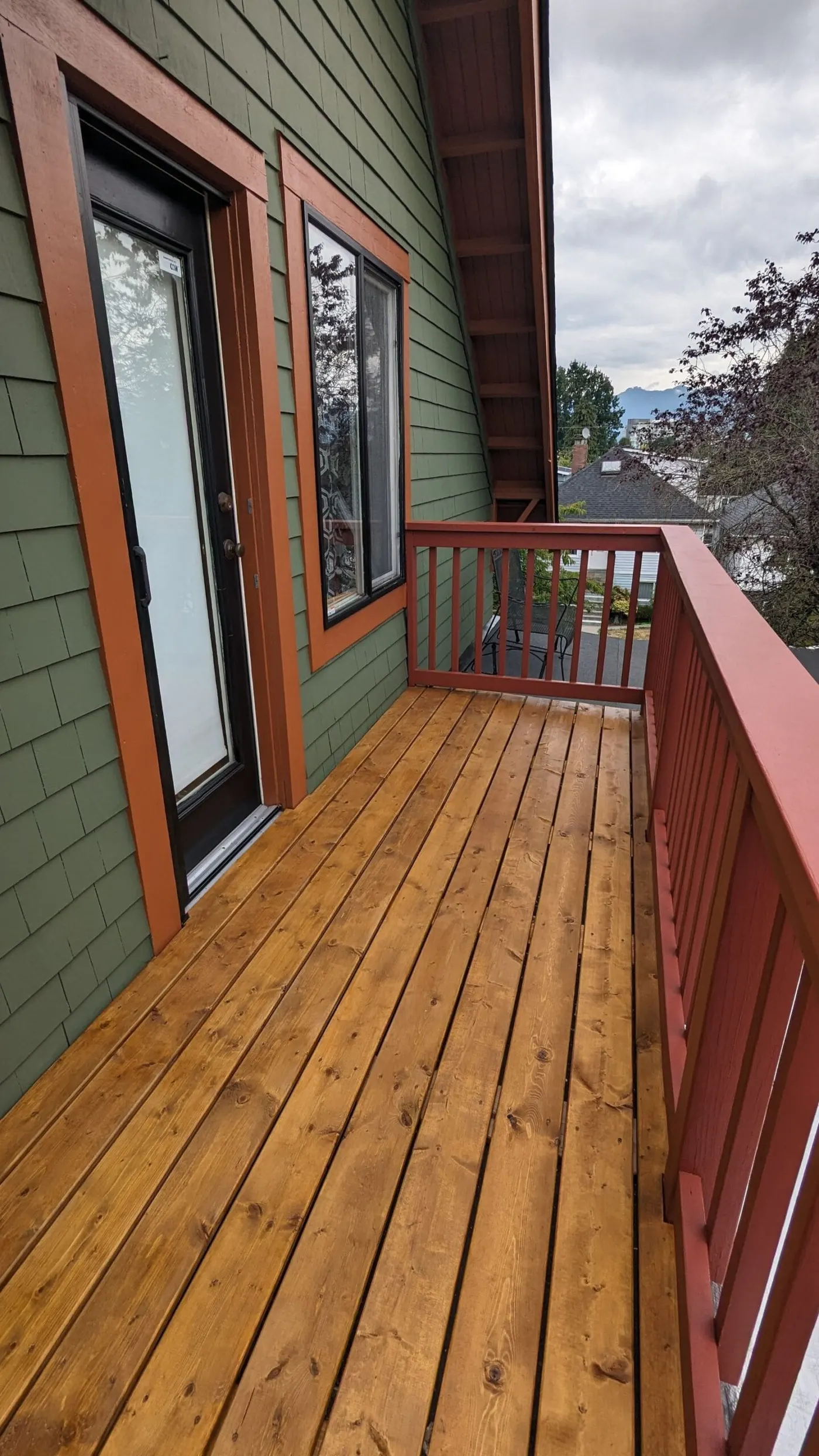 Wooden deck with red railing, full deck rebuild service