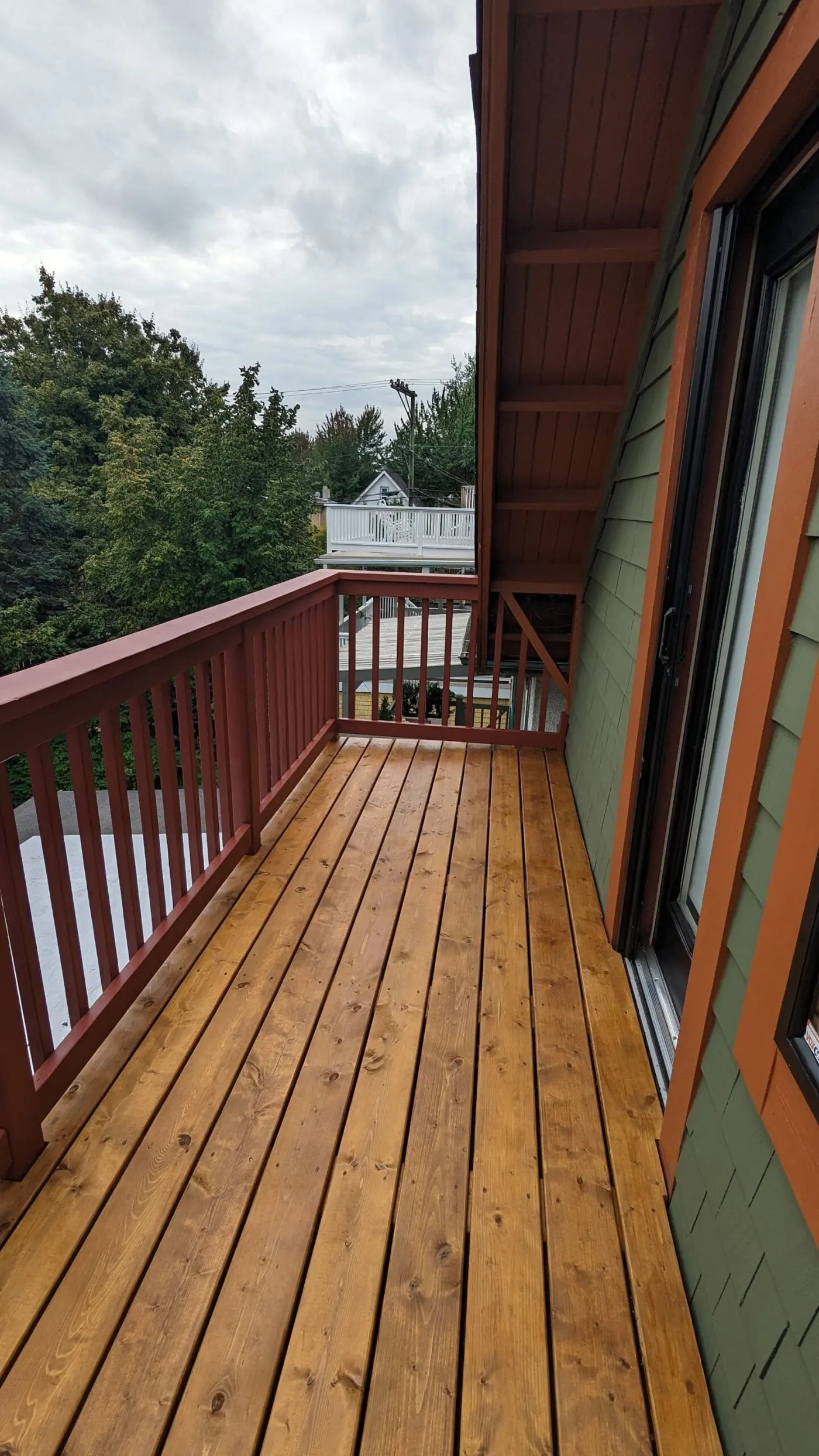 Wooden deck with green and brown siding, custom deck installation