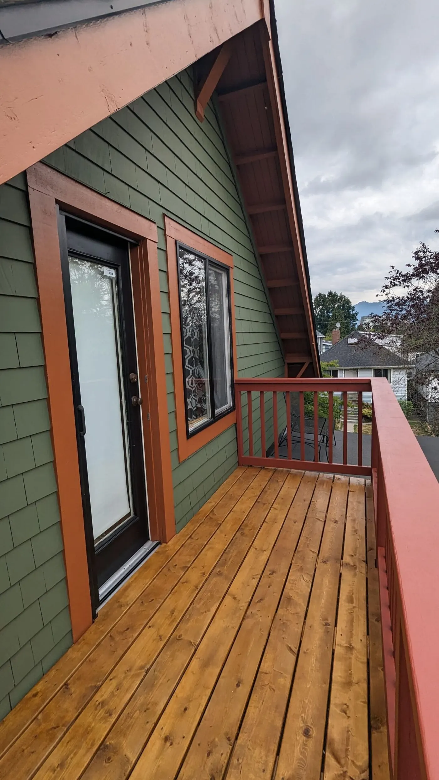Wooden deck with red railing and house, deck restoration service