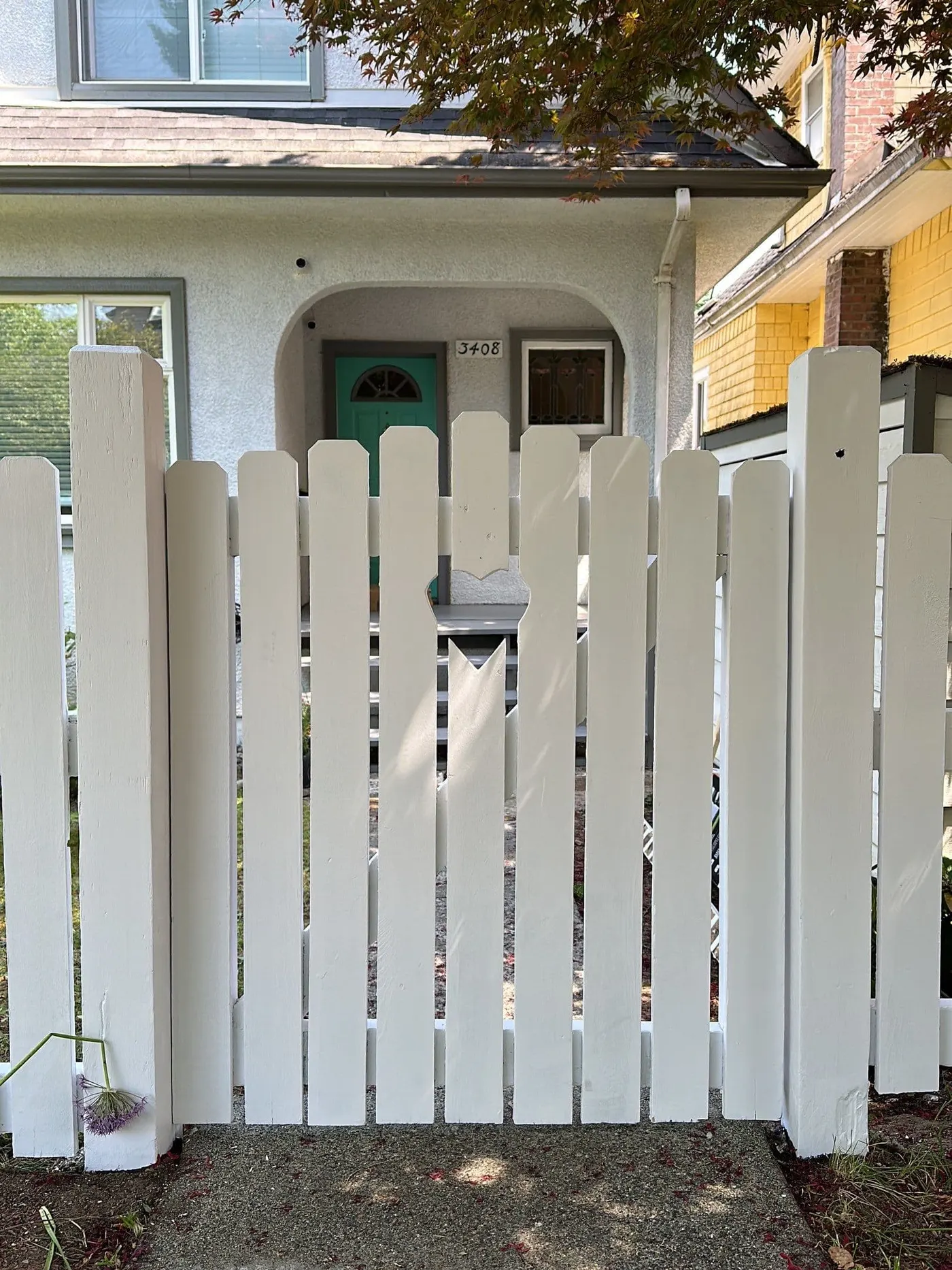 White fence, repaired boards and refreshed paint finish