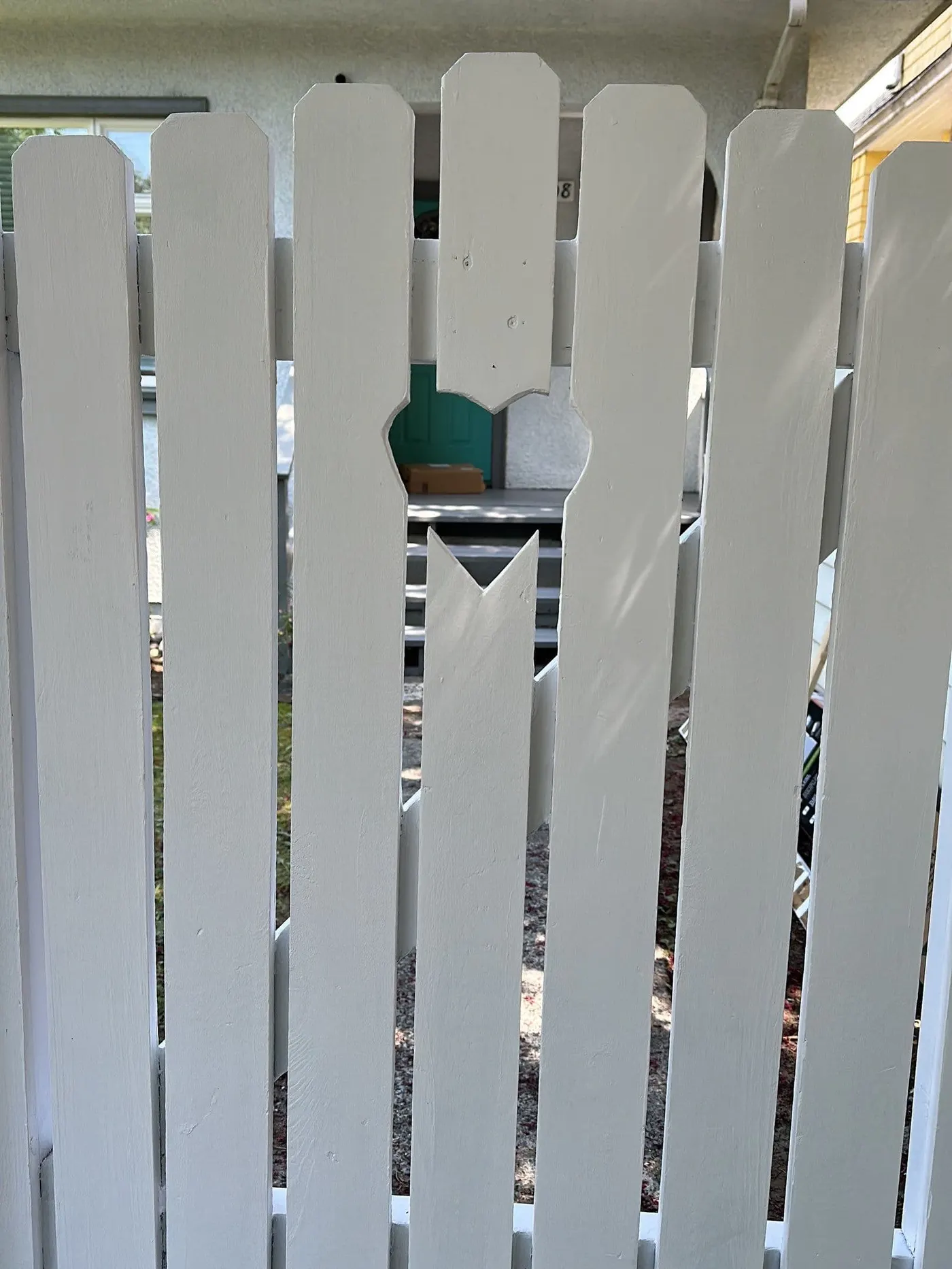 Cat sitting on white fence, newly painted for restored curb appeal