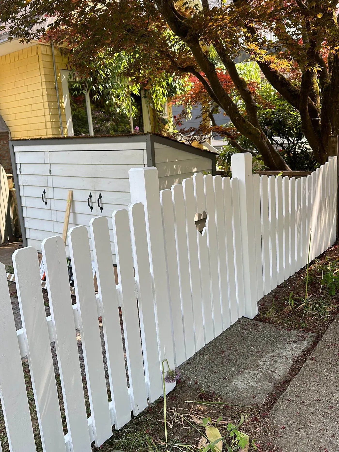 White picket fence fully restored with painting and post replacement