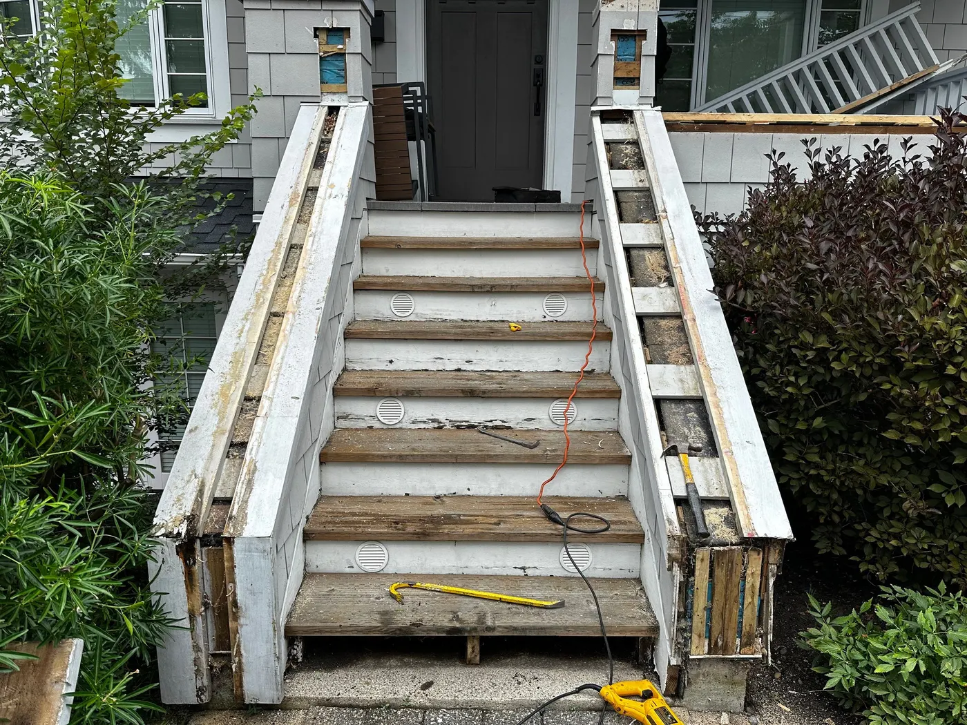 Open wooden stair framing and stringers exposed after tread removal on a residential staircase rebuild in Vancouver, BC.
