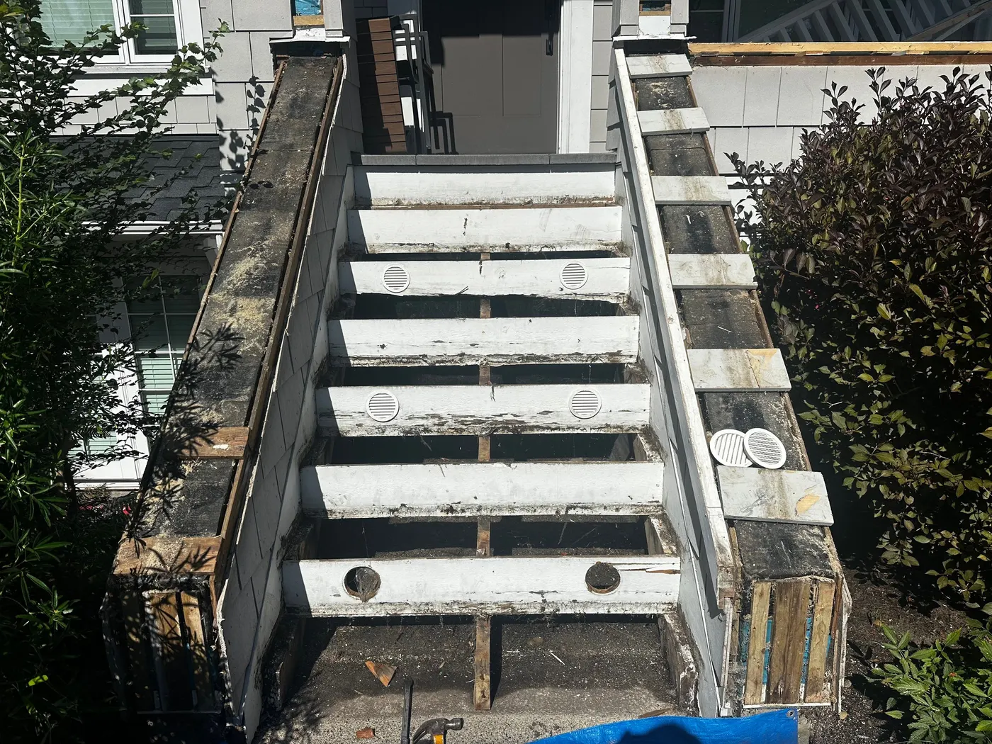 Overhead view of a residential staircase in Vancouver, BC stripped completely down to bare joists and framing during a rebuild.