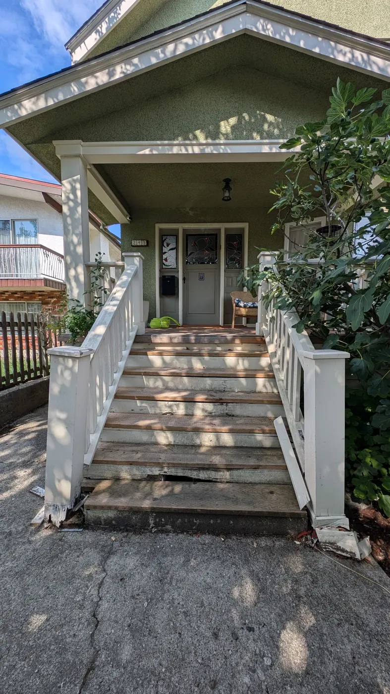 Deteriorated wooden front porch stairs with visible rot and peeling paint on a Vancouver character home, before Renaissance Painting's carpentry repair.