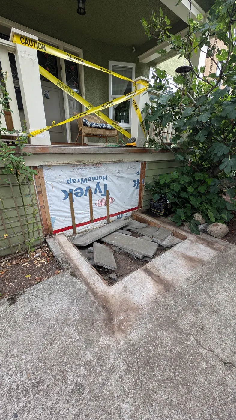 Porch stair demolition site with caution tape and exposed house wrap on a Vancouver home during Renaissance Painting's carpentry repair.
