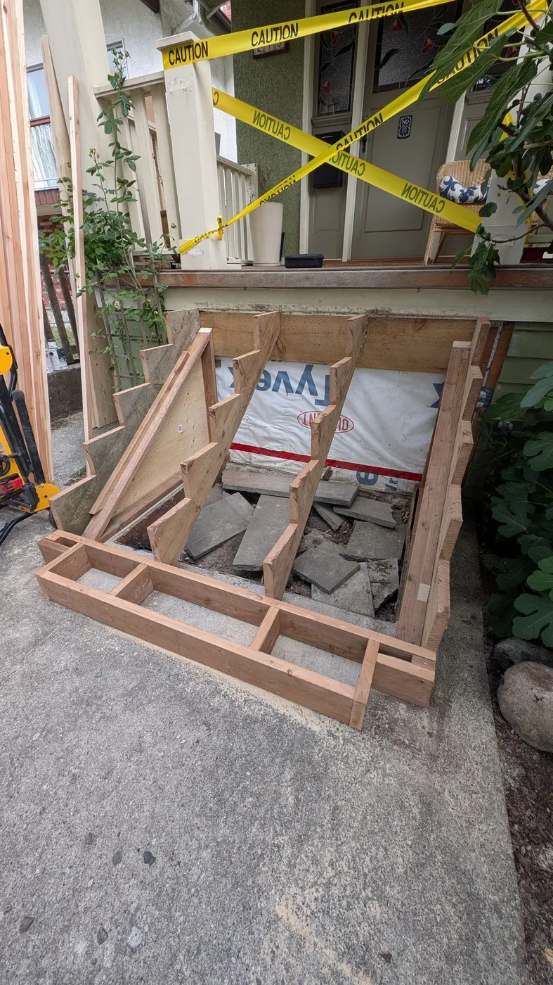 New pressure-treated wood stringers and stair framing under construction at a Vancouver home, replacing rotted stairs.