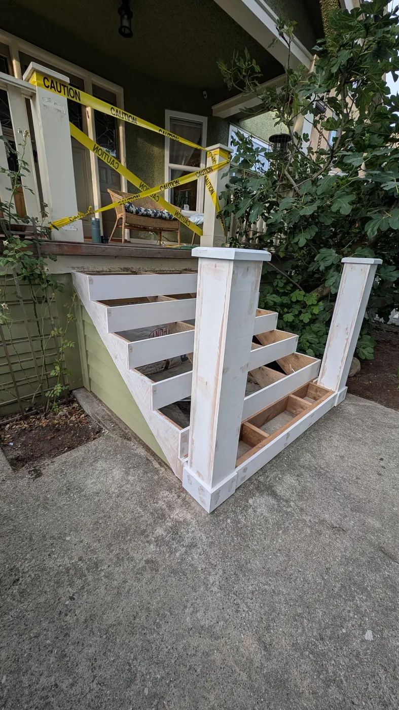 Newly built stair carcass primed white, awaiting tread installation, on a Vancouver character home porch.