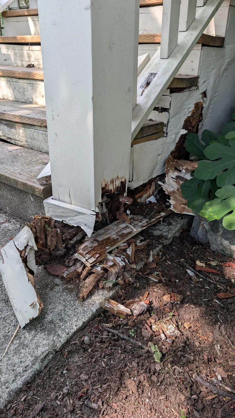 Rotted stair post foundation with crumbling wood fibers exposed at a Vancouver residence, documented ahead of carpentry repairs.