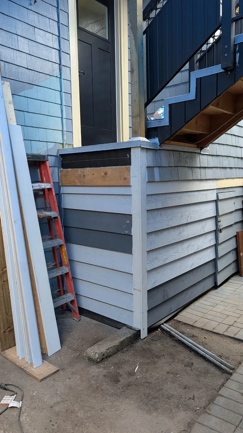 Custom wood deck frame under construction beside a rear entry stairway on a Vancouver, BC property