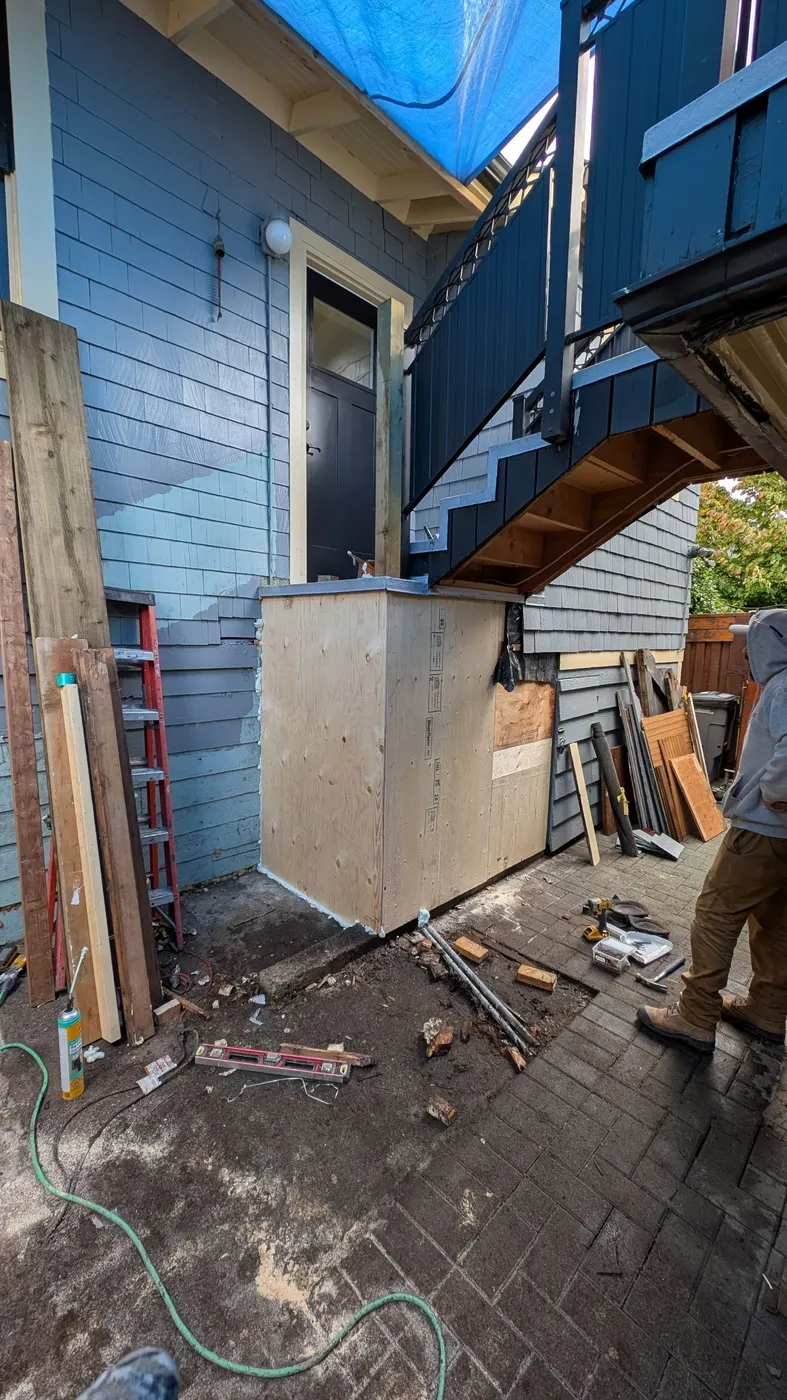 Newly rebuilt wall cavity with fresh plywood sheathing and spray foam sealing during a Vancouver carpentry repair