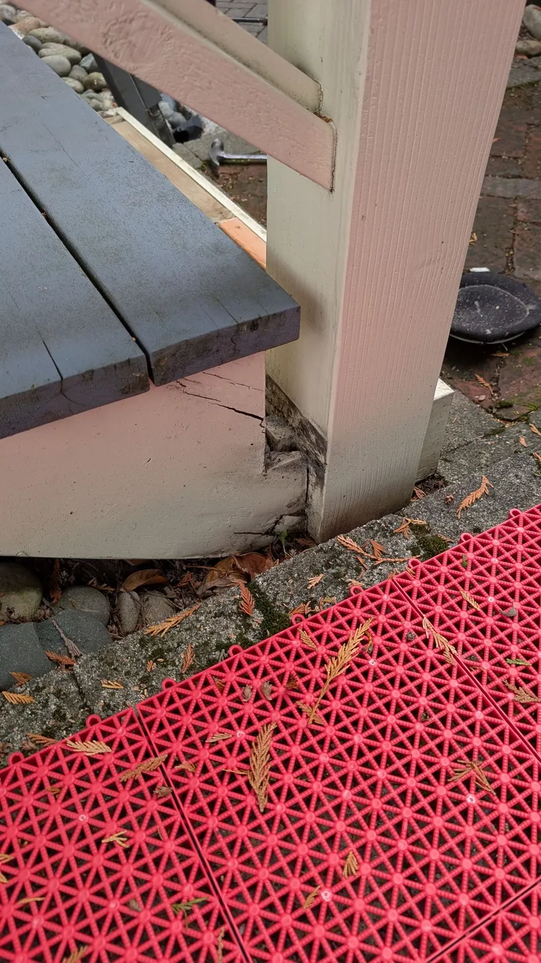 Cracked wood trim and fascia at a deck stair corner post showing structural damage, Vancouver BC residential carpentry.