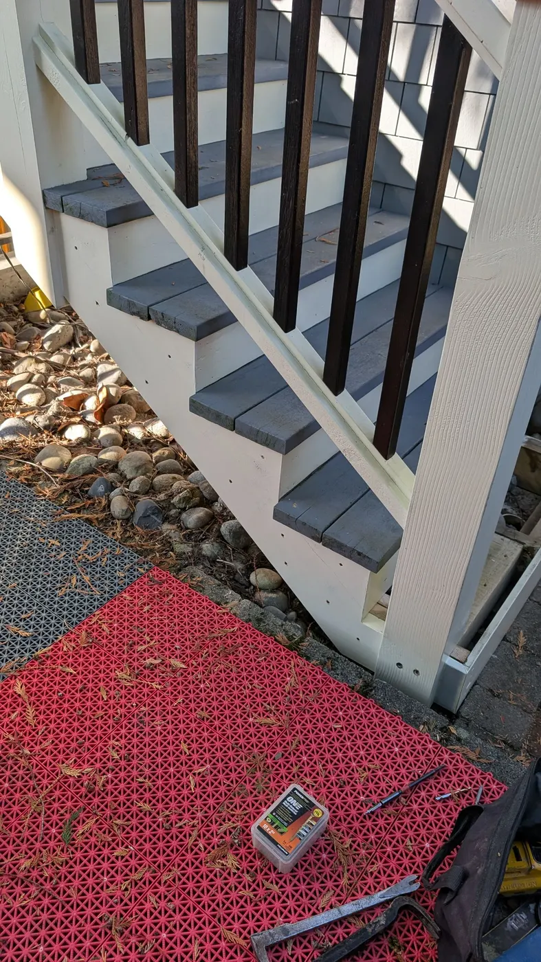 Wide view of a completed and painted exterior wood staircase with black railings on a Vancouver, BC residence.