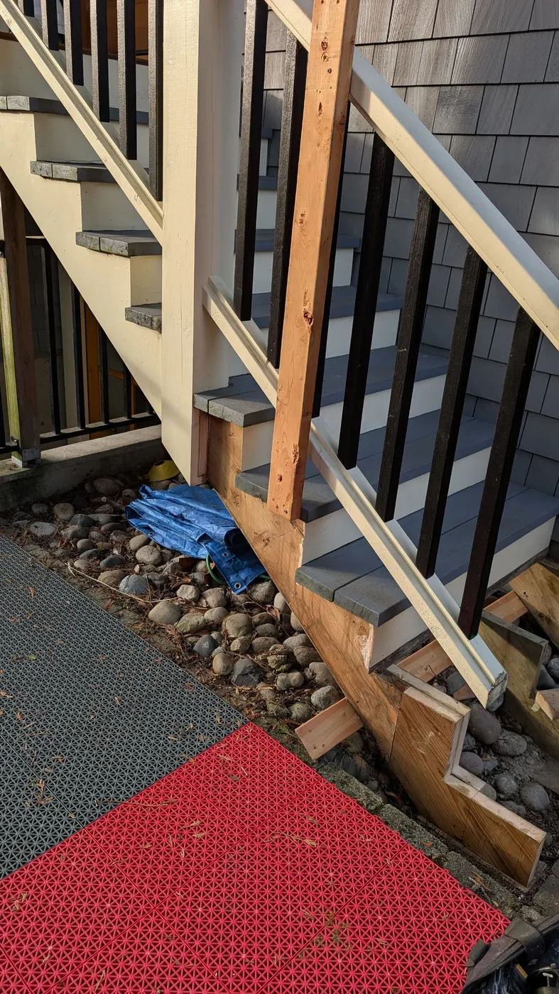 Freshly painted exterior wood staircase with repaired post base, cream and grey trim, on a Vancouver, BC home.