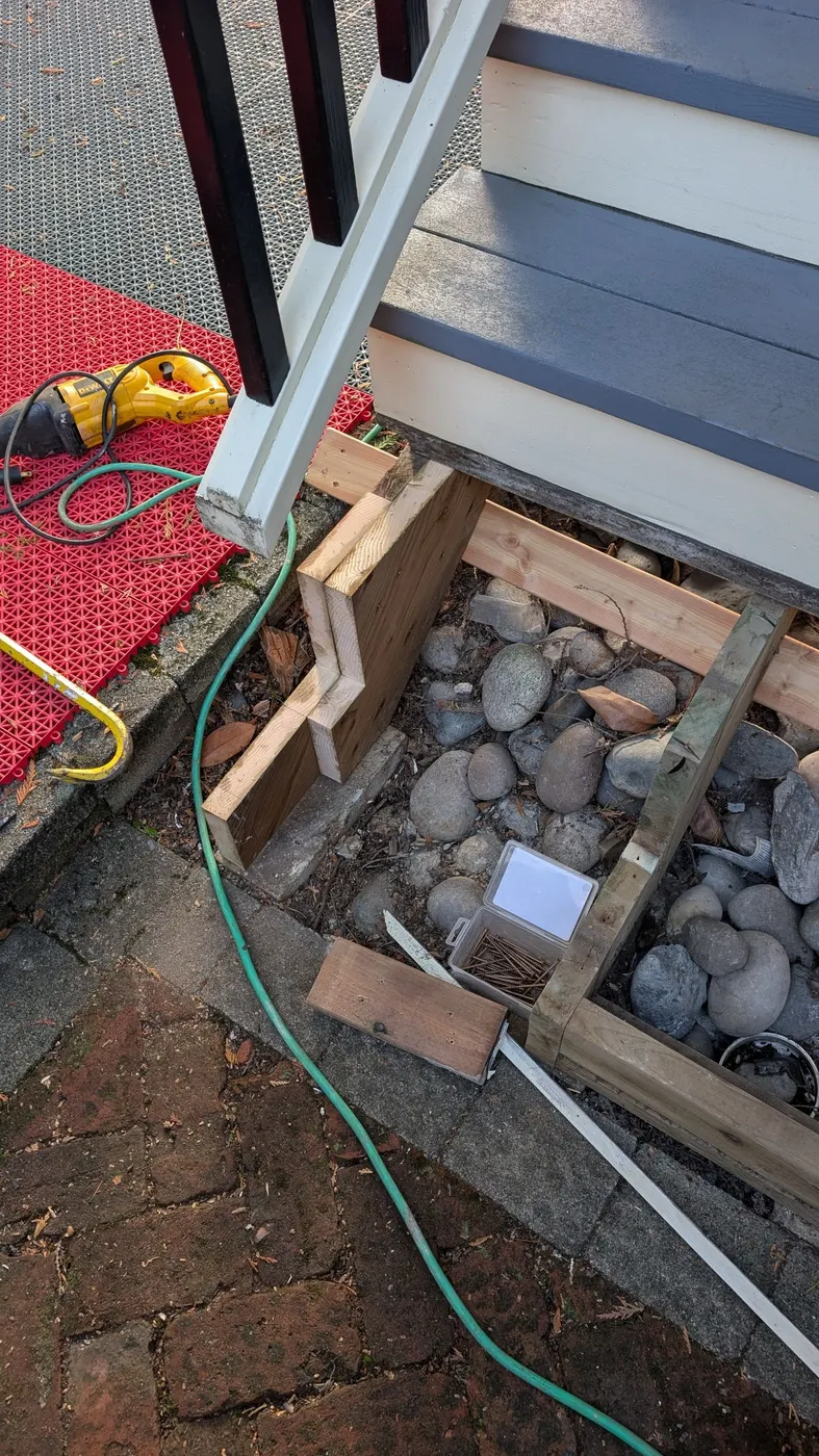 New pressure-treated wood framing being installed beneath an exterior staircase during a carpentry repair in Vancouver, BC.