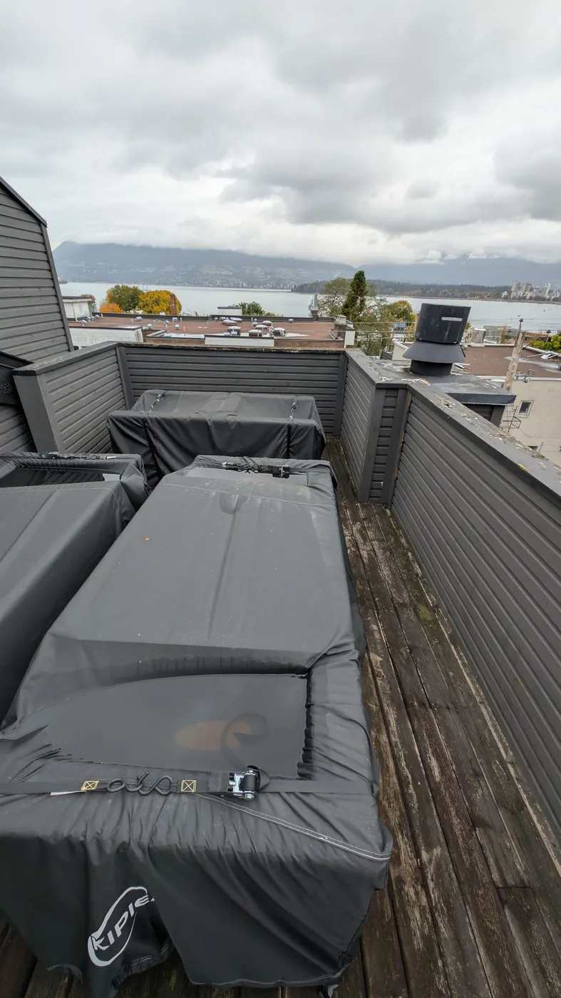 Freshly painted dark parapet cap and siding on a Vancouver penthouse rooftop deck overlooking English Bay