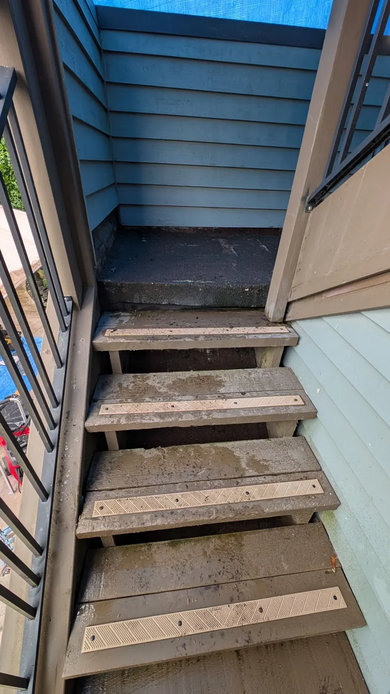 Weathered wooden exterior stairwell with mossy treads before carpentry repairs on a Vancouver, BC townhome.