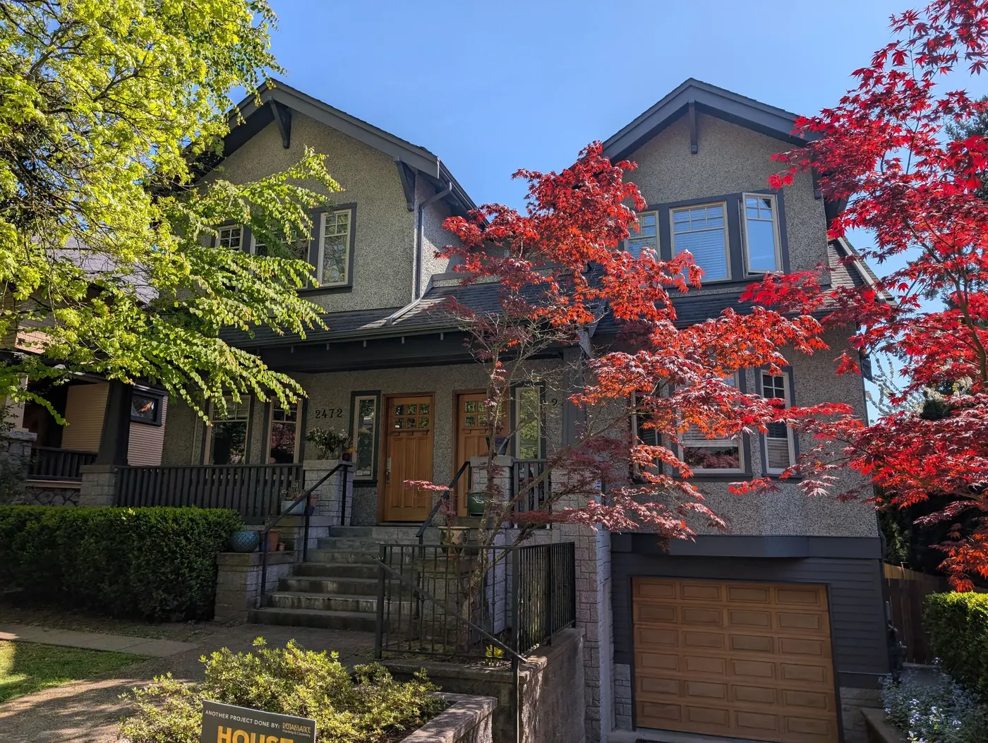Freshly painted Craftsman-style house exterior in Vancouver, BC with dark trim and grey stucco.