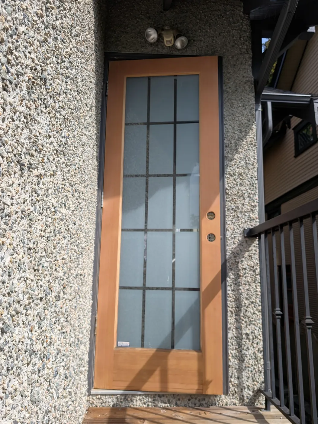 Finished wood-framed glass side door on a Vancouver home after exterior painting and staining.