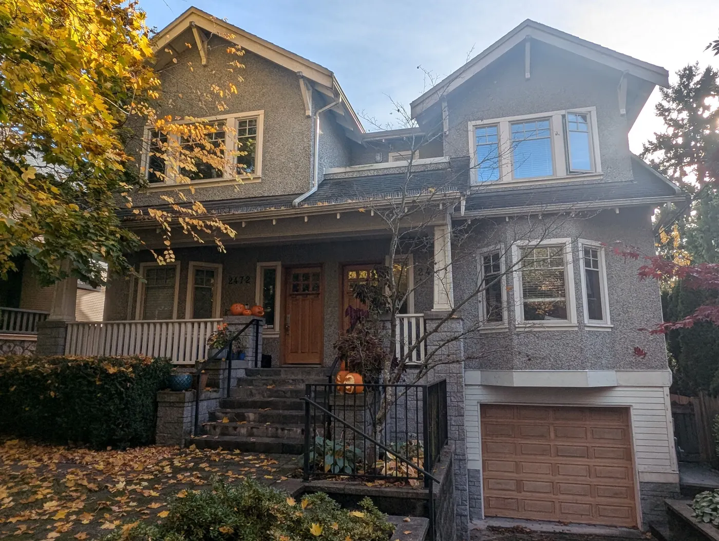 Craftsman-style house exterior in Vancouver, BC before repainting, showing weathered stucco and trim in autumn.