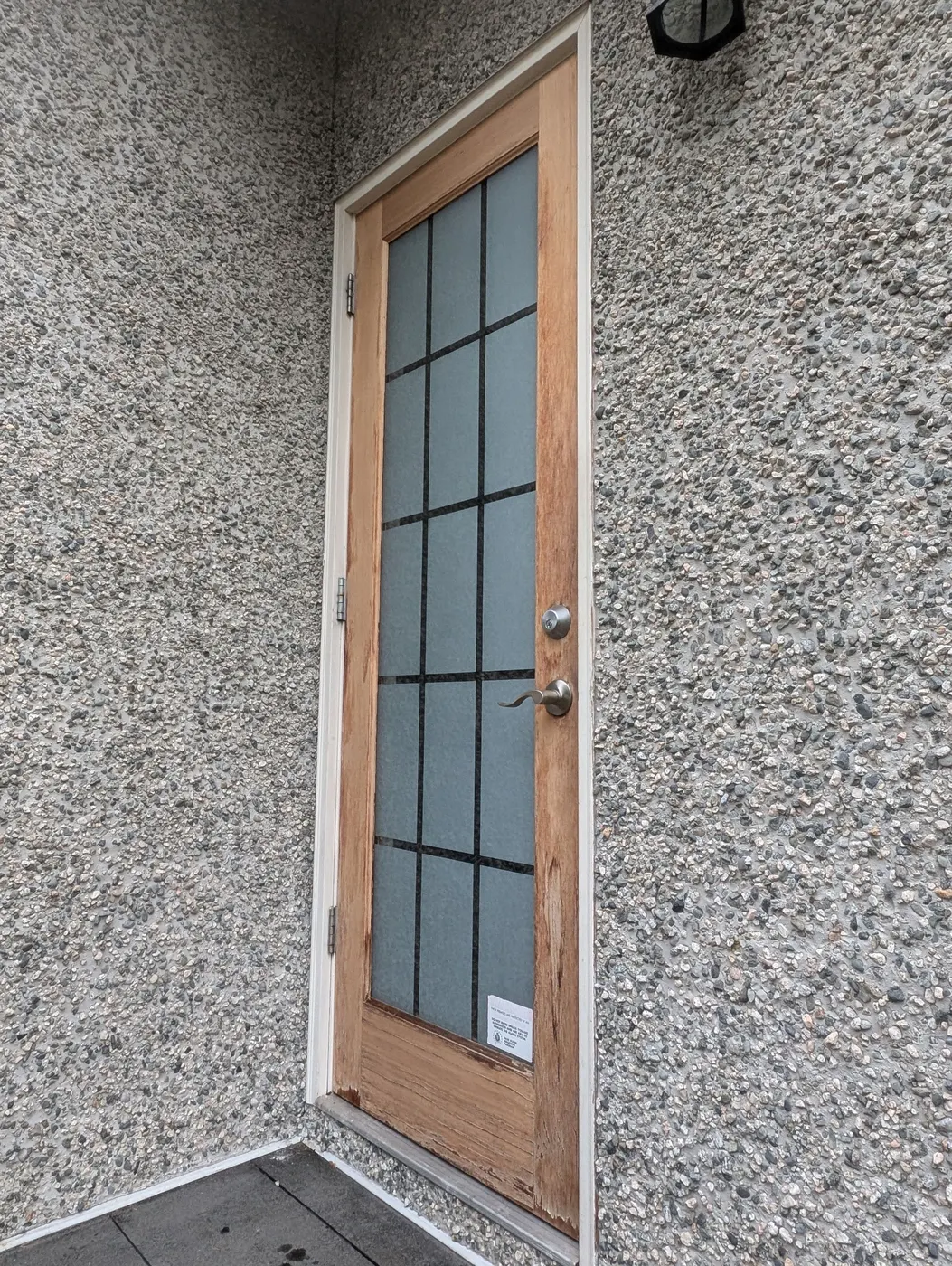 Bare wood exterior door with glass panes on a Vancouver house before staining and painting.