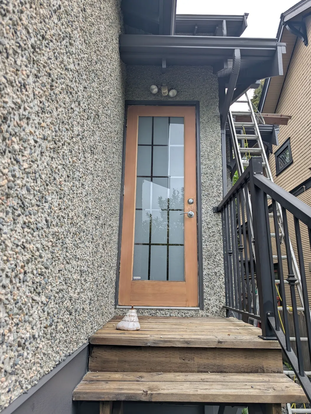 Side entry door and stairway of a Vancouver home mid-way through the exterior painting project.