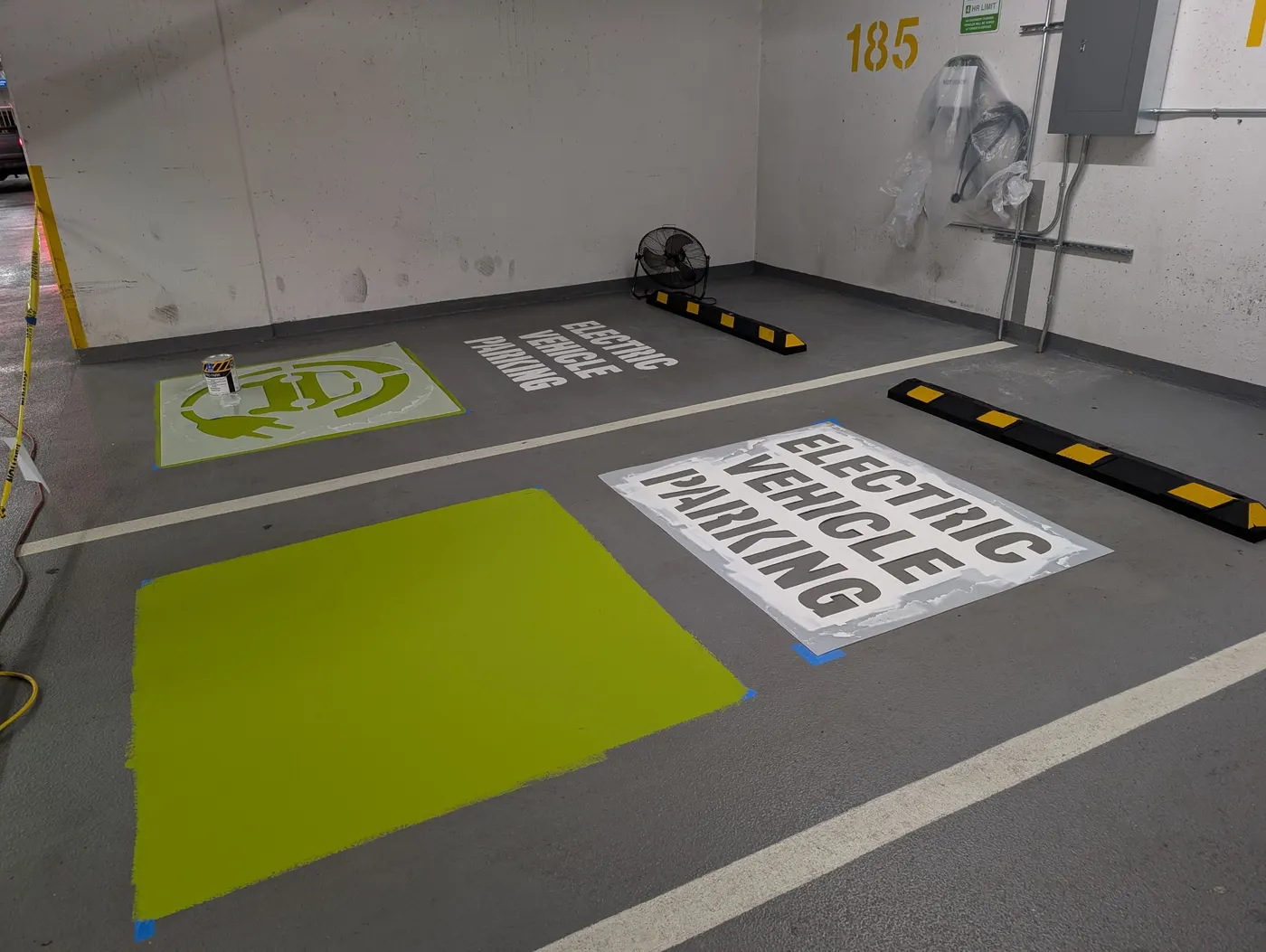 Completed green EV parking symbol and Electric Vehicle Parking text stenciled onto a Vancouver condo garage floor.