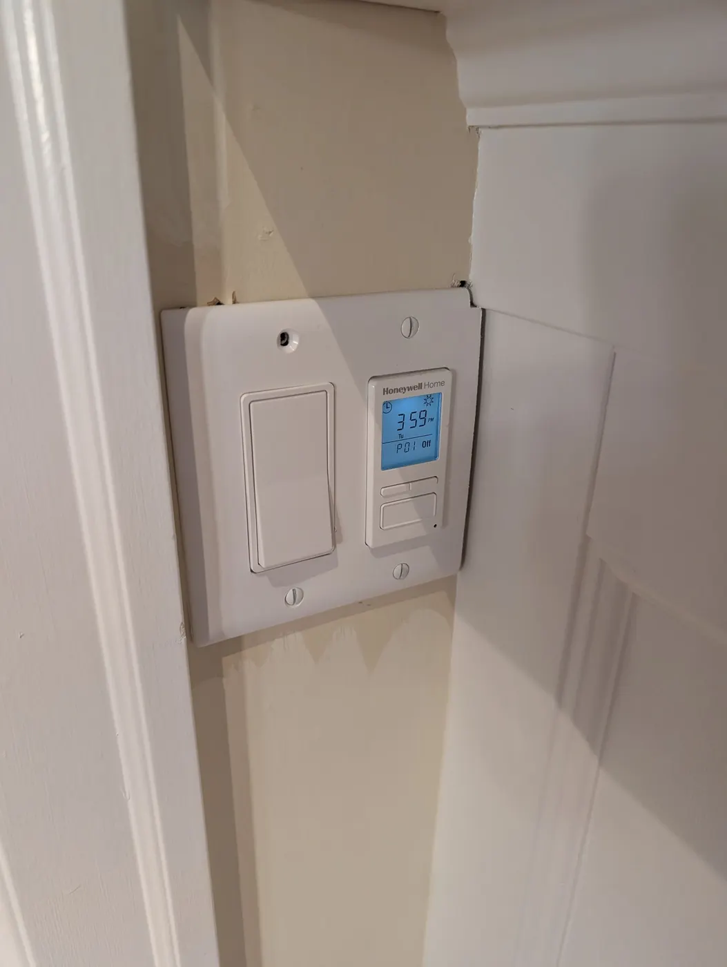 Freshly painted white door trim and baseboard around a light switch and smart thermostat, part of an interior painting project in Vancouver, BC.