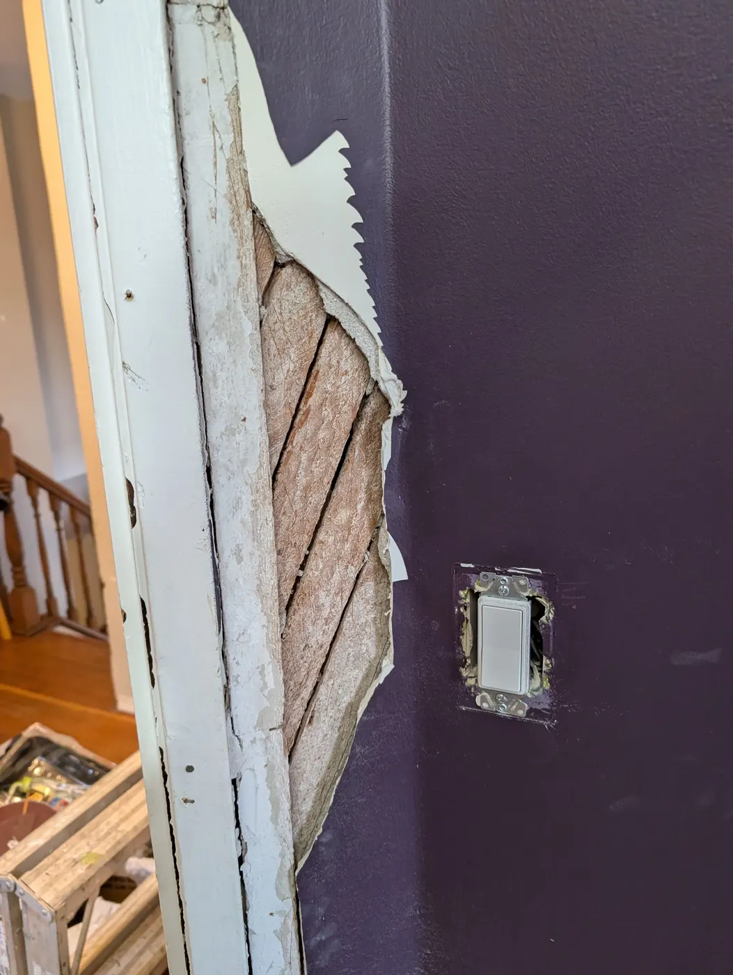 Exposed wood lath and damaged plaster wall during an interior repair in a Vancouver, BC home, ahead of drywall patching and painting