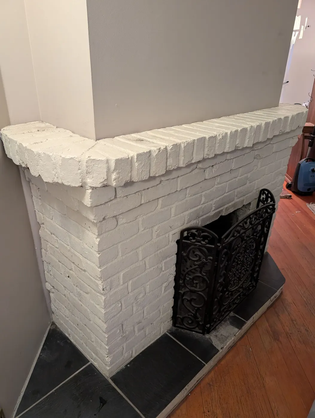 Freshly painted white brick fireplace and mantel in a Vancouver, BC living room