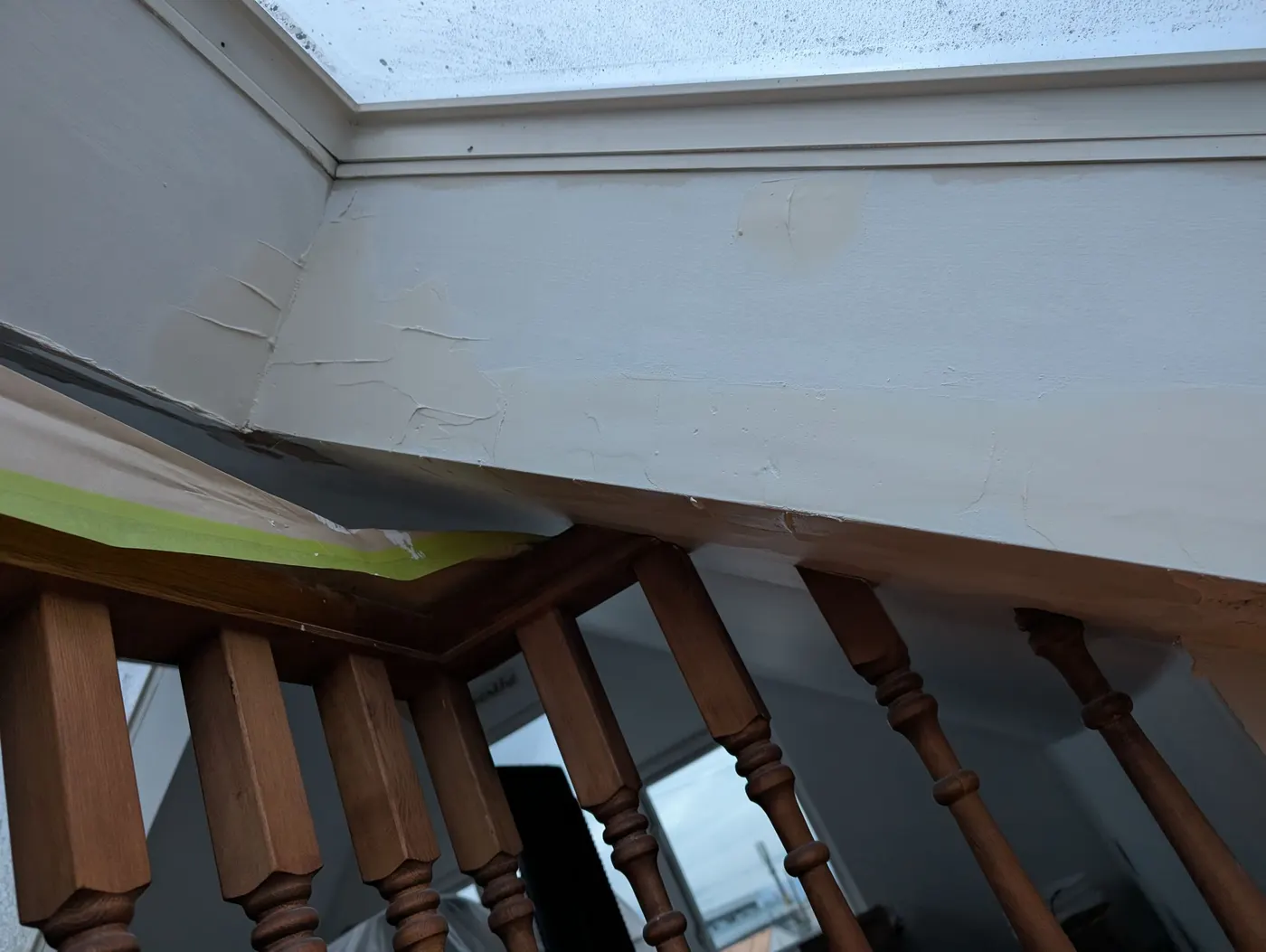 Painter patching and taping trim around a skylight dormer during an interior renovation in Vancouver, BC