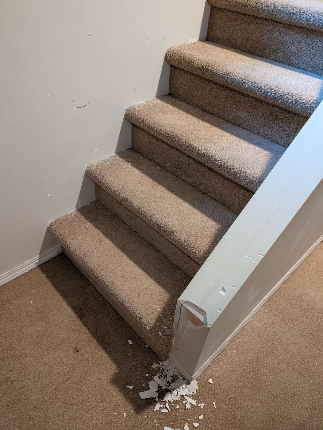 Damaged stair newel post corner before carpentry repair in a Vancouver, BC home