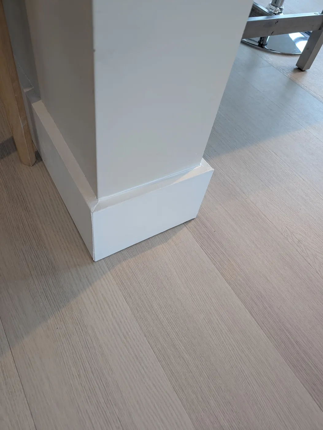 Freshly painted white baseboard trim corner in a Vancouver, BC condo after interior finishing work.