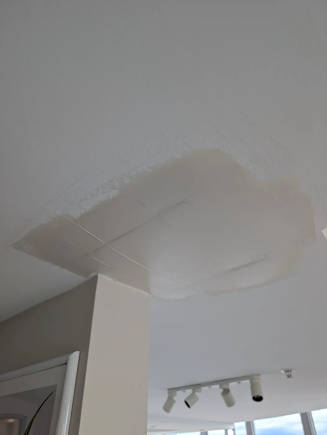 Sanded and mudded ceiling drywall patch ready for primer and paint in a Vancouver, BC condo interior.