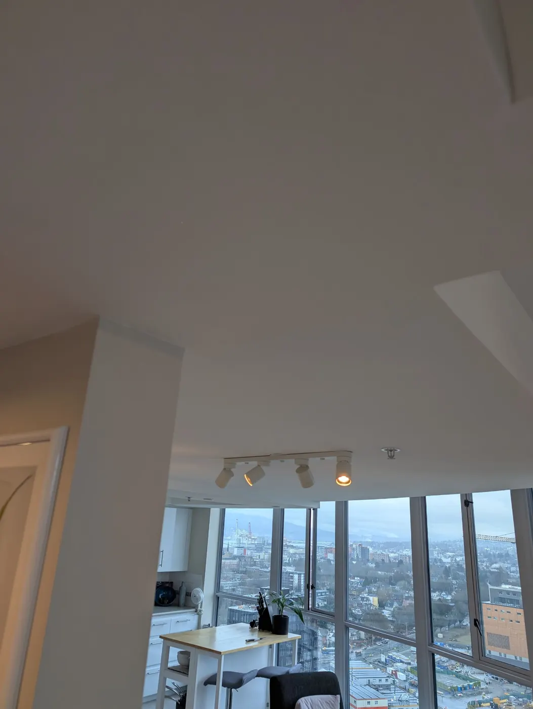 Completed, seamless ceiling repair and repaint in a Vancouver, BC high-rise condo with city and mountain views.
