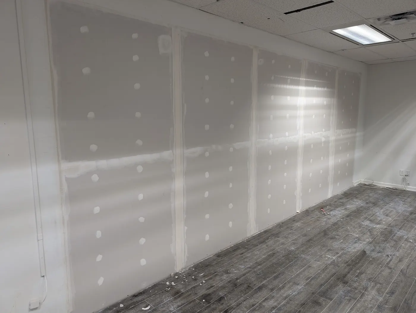 Freshly patched drywall panels ready for priming in a Vancouver commercial interior renovation