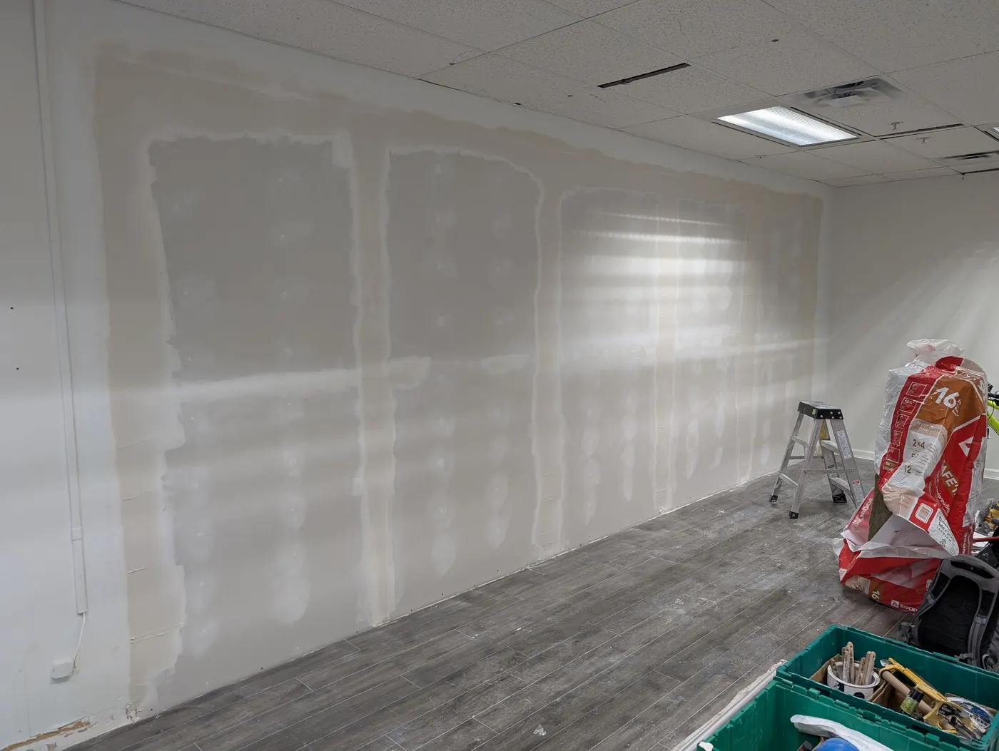 Drywall patches and insulation materials staged during an interior renovation in Vancouver, BC