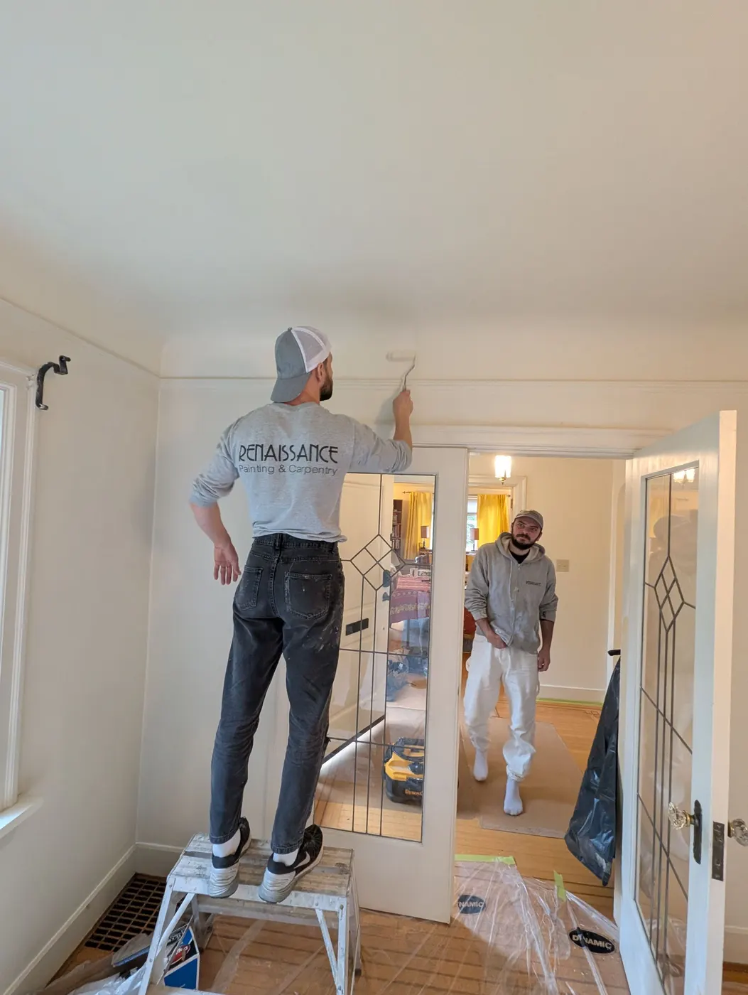 Renaissance Painting crew member rolling ceiling trim during an interior repaint in Vancouver, BC