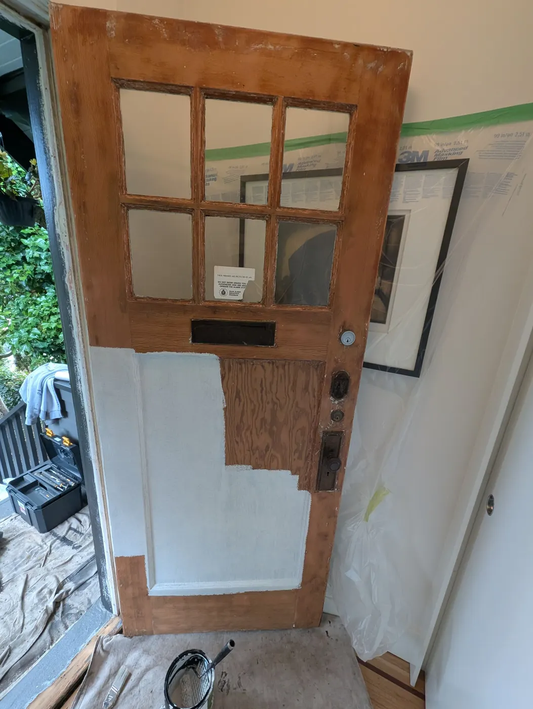 Original wood front door being refinished and repainted for a Vancouver, BC duplex renovation